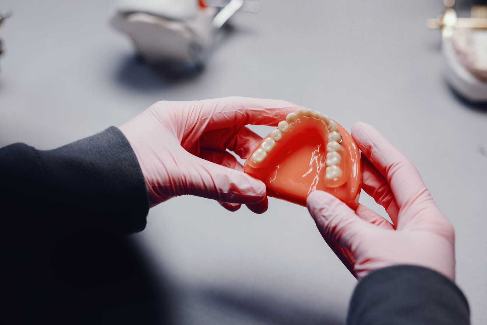 Proteza akrylowa w dłoniach dentysty – naprawa protez w gabinecie w Gliwicach