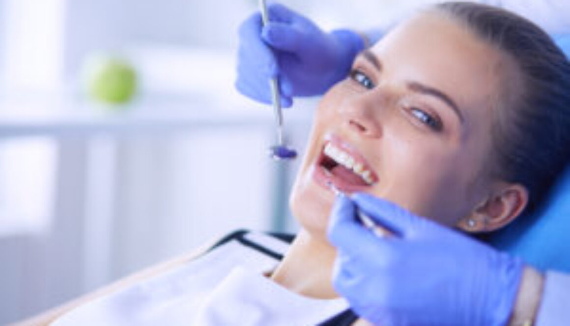 Young Female patient with open mouth examining dental inspection at dentist office. Young Female patient with open mouth examining dental inspection at dentist office.