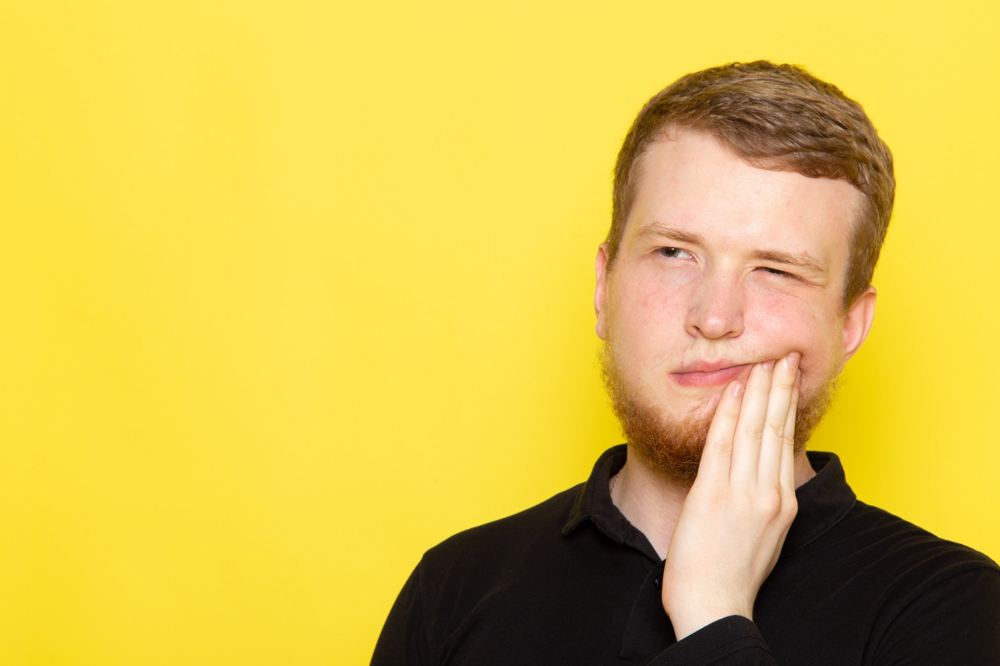 front-view-young-male-black-shirt-posing-having-toothache-min