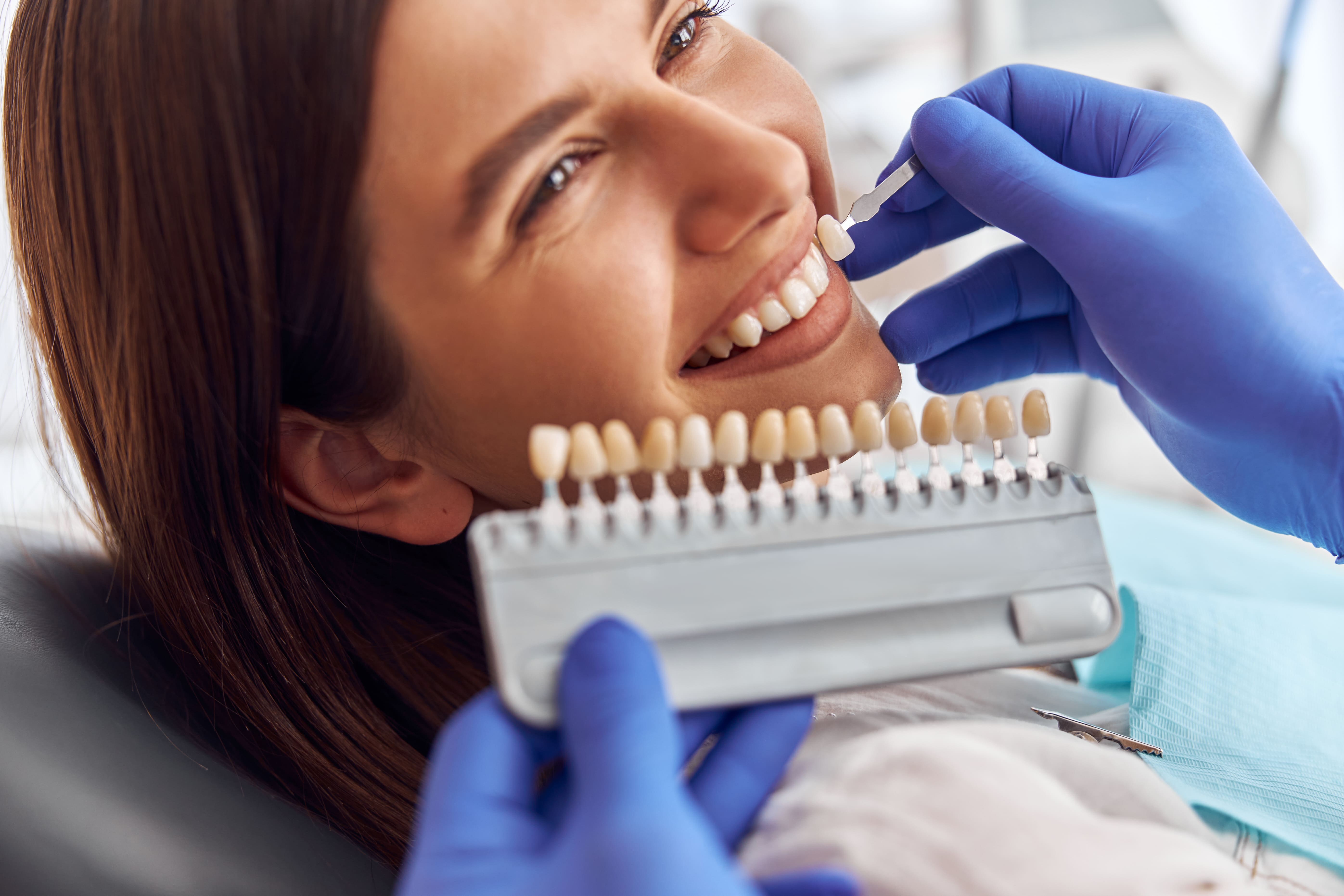 male-doctor-stand-upon-client-put-artificial-teeth-true-ones-whitening-procedure-tooth-replacing-min