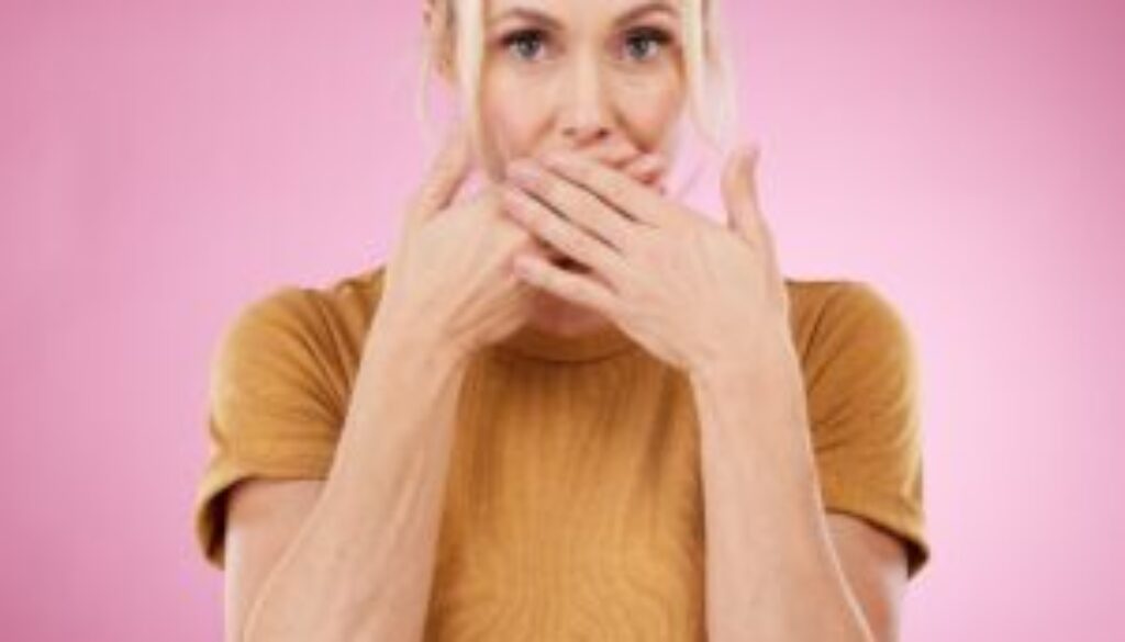 secret-studio-woman-with-her-hand-her-mouth-with-shock-surprise-quiet-face-expression-gossip-shocked-portrait-female-model-with-surprised-gesture-isolated-by-pink-background-min